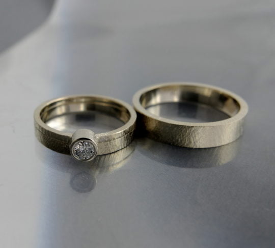 obrączki z białego złota z fakturą i pierścionek z brylantem