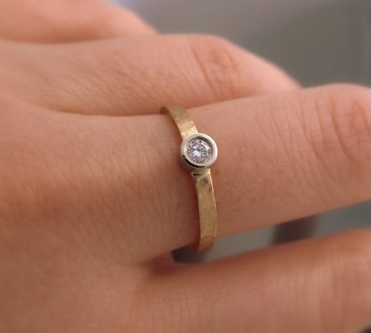 pierścionek młotkowany z brylantem na palcu