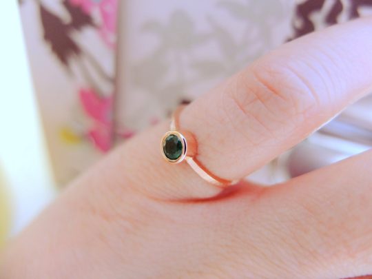 minimalistyczny złoty pierścionek szmaragd na palcu