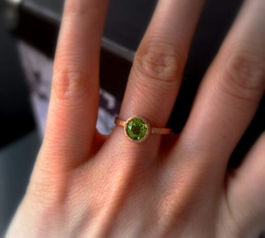 minimalistyczny pierścionek z perydotem na palcu