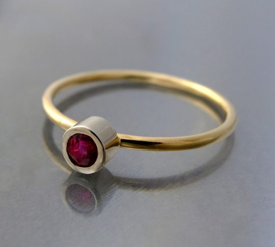 minimalistyczny złoty pierścionek z rubinem na palcu