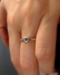 minimalistyczny pierścionek z szafirem na palcu