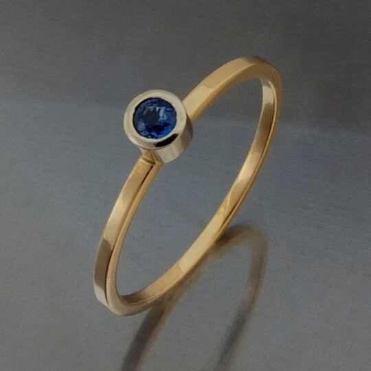 pierścionek zaręczynowy na serdecznym palcu złoty z niebieskim szafirem