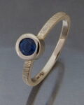 pierścionek zaręczynowy na serdecznym palcu złoty z niebieskim szafirem