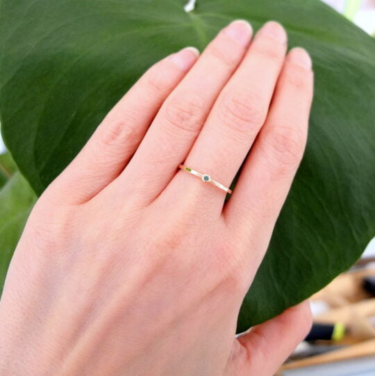 subtelny pierścionek na palcu ze szmaragdem 1,5 mm oprawionym w różowe złoto próby 585