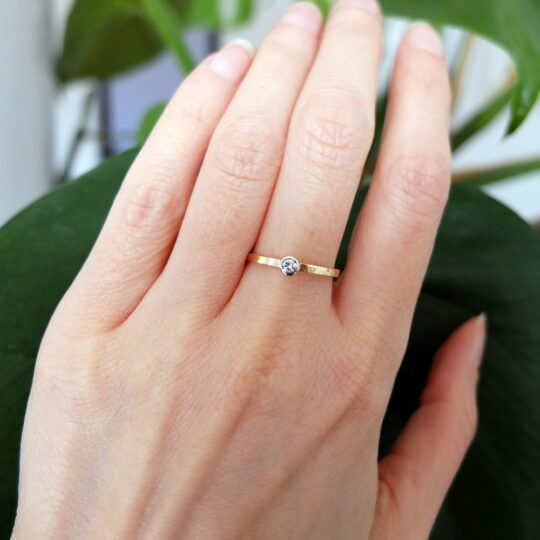 młotkowany złoty pierścionek marki BIZOE z brylantem na palcu idealny na zaręczyny